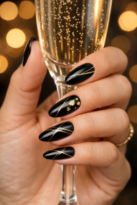 New Year's Eve nails in Airdrie, glossy black almond manicure with thin metallic gold lines holding a champagne glass at Top Nails 3