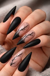 Matte black stiletto nails with nude negative space accents and minimalist black branch line art, bold Nail Trends 2026 at Top Nails 3 Airdrie