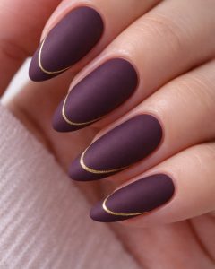 Matte plum almond nails with delicate gold curved line design, International Women’s Day Nail Trends 2026 by Top Nails 3