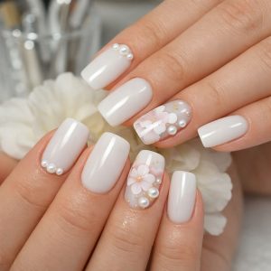 White glossy coffin nails with pearl accents and delicate 3D flower nails design at Top Nails 3 Airdrie