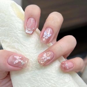 Soft nude nails with glitter and crystal floral decorations Floral Nails 2026 at Top Nails 3 Airdrie