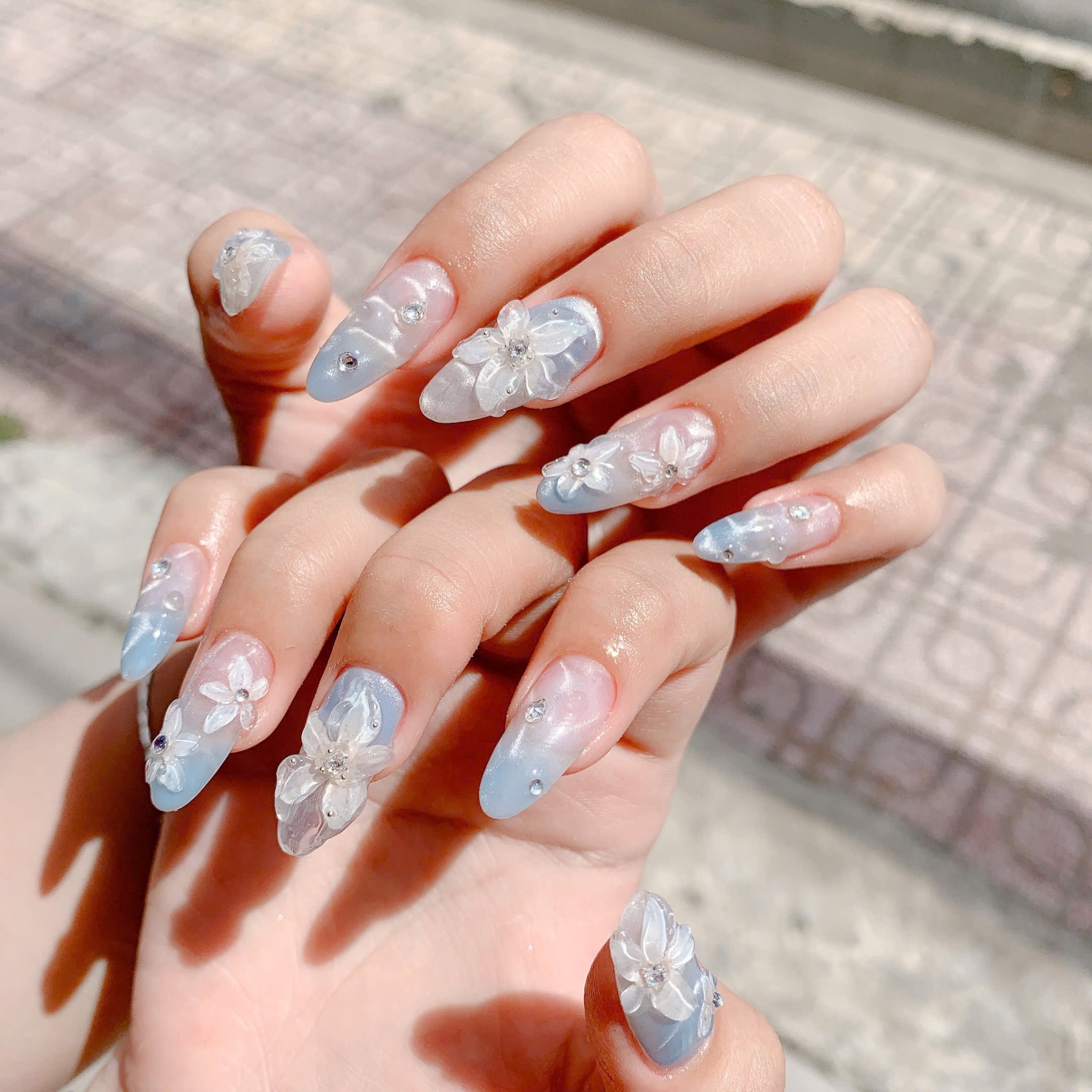 Blue ombre nails with 3D flower accents and rhinestones Floral Nails 2026 at Top Nails 3 Airdrie