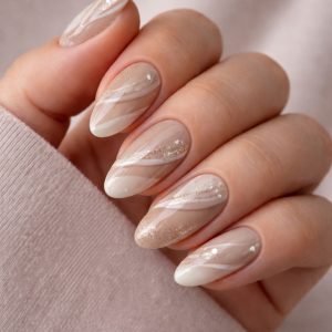 Neutral beige mix texture nails with marble swirls, glitter accents, and glossy finish on almond-shaped nails at Top Nails 3 Airdrie